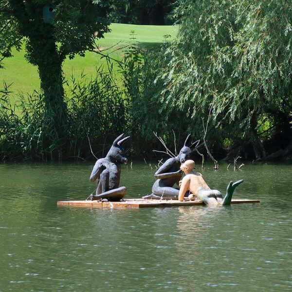 Skulpturen auf einem Floß im Giessenparksee. Kunstinstallation im Park.