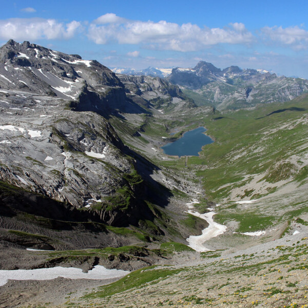 Glattalpsee: Bergsee in den Schweizer Alpen mit schneebedeckten Gipfeln und grünen Tälern.