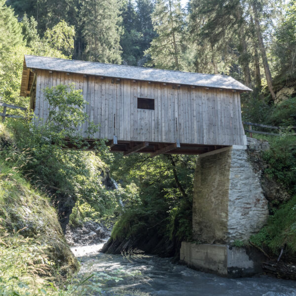 Gedeckte Holzbrücke über den Glenner Fluss in Graubünden, Schweiz.