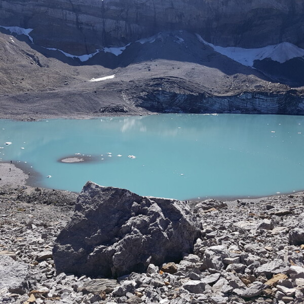 Türkisblauer Griesslisee in den Schweizer Alpen, umgeben von Felsen und Schnee