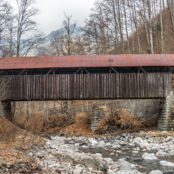 Grosse Melchaa: Gedeckte Holzbrücke über einen Fluss in der Schweiz.