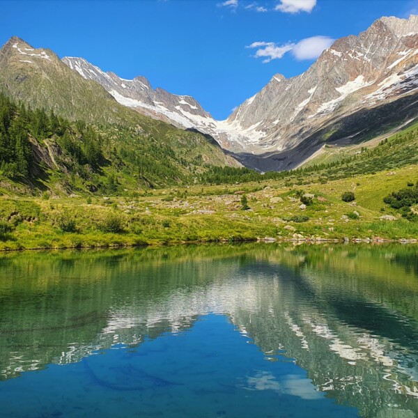 Grundsee: Bergsee mit Spiegelung der schneebedeckten Alpenlandschaft im klaren Wasser.
