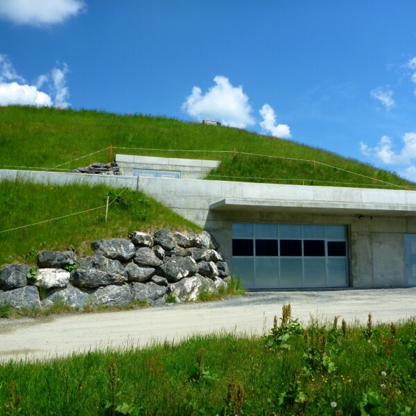 Hintere Hütte Speichersee: Gebäude im Gras eingebettet, mit Garage und Steinen.