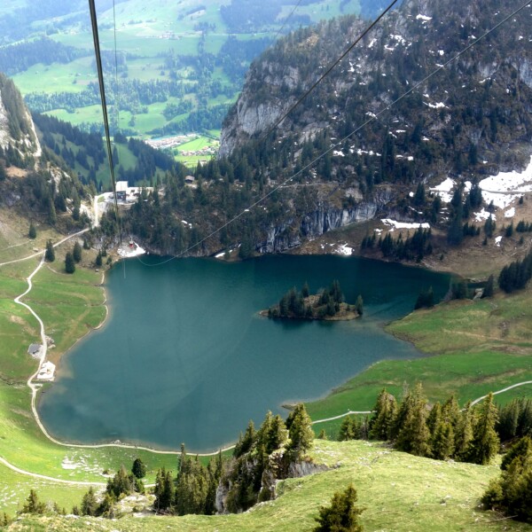 Hinterstockensee Ansicht von oben mit Bergen und grünen Wiesen.
