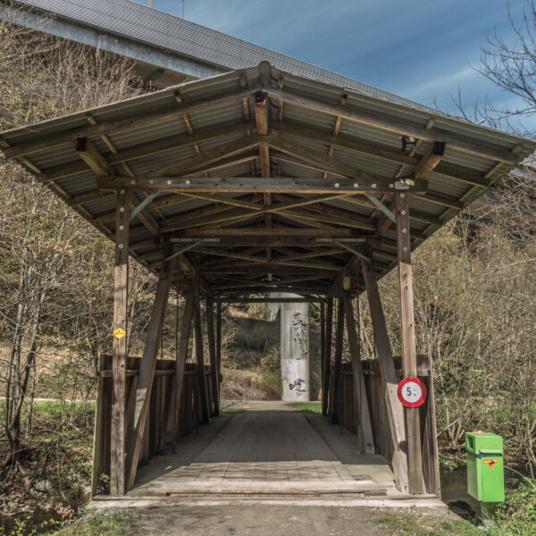 Überdachte Holzbrücke in Jonen mit Geschwindigkeitsbegrenzung.