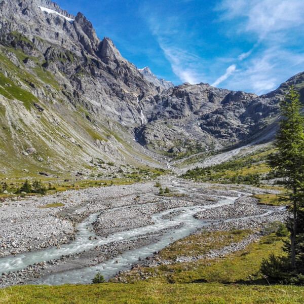 Kander-Tal: Fluss windet sich durch steinige Landschaft unter hohen Bergen.