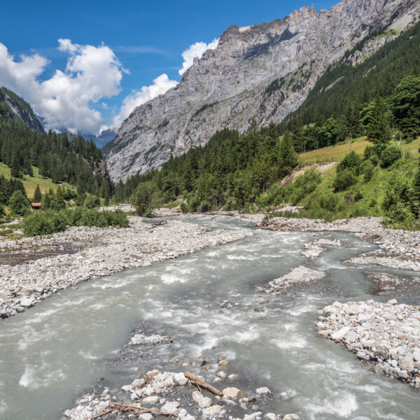 Kander: Wildfluss durch steiniges Flussbett in Berglandschaft