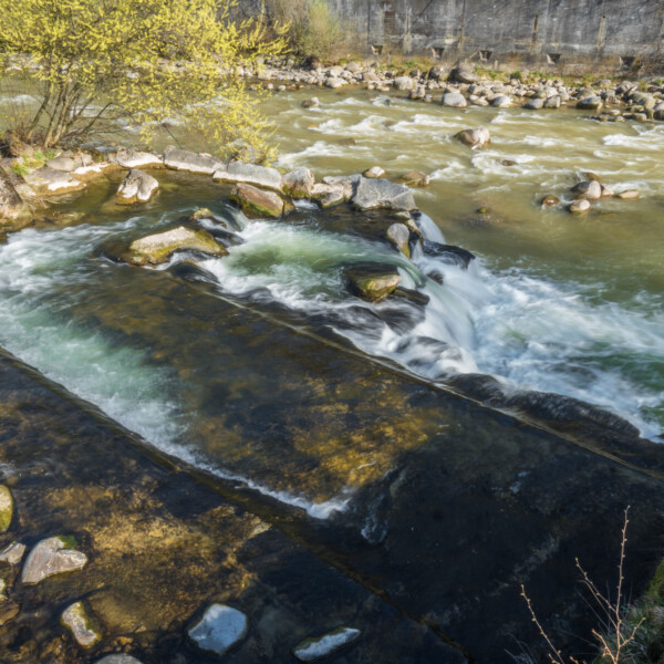 Kleine Emme Fluss mit Steinen und einem kleinen Wasserfall in der Schweiz.