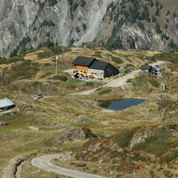 Berglandschaft mit Berghütte am Lac Brunet, Schweiz. Wanderweg im Vordergrund.