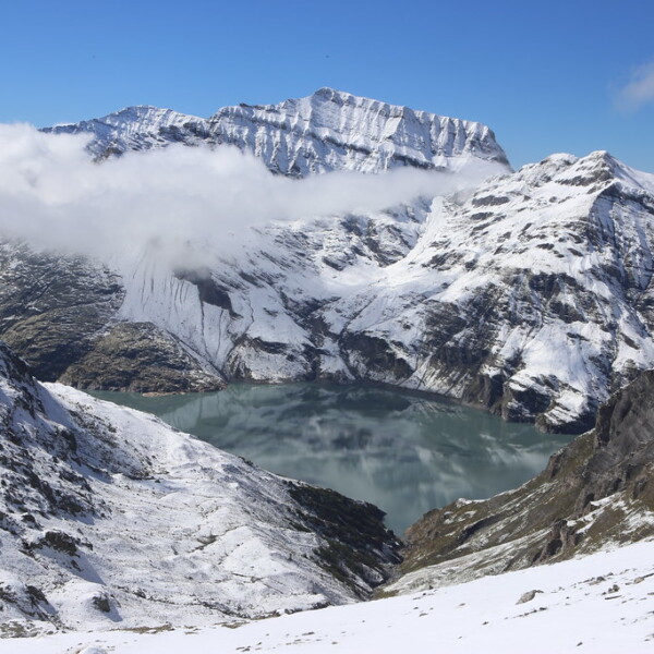Lac d'Emosson: Bergsee umgeben von schneebedeckten Bergen im Winter.