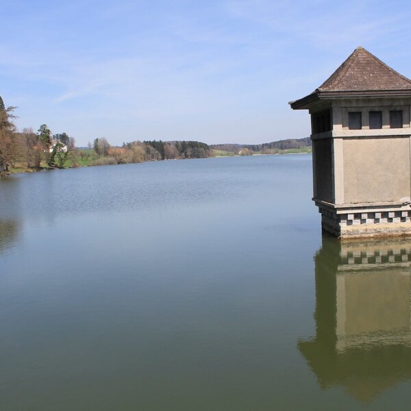 Turm am Lac de Bret-See mit Spiegelung im Wasser.