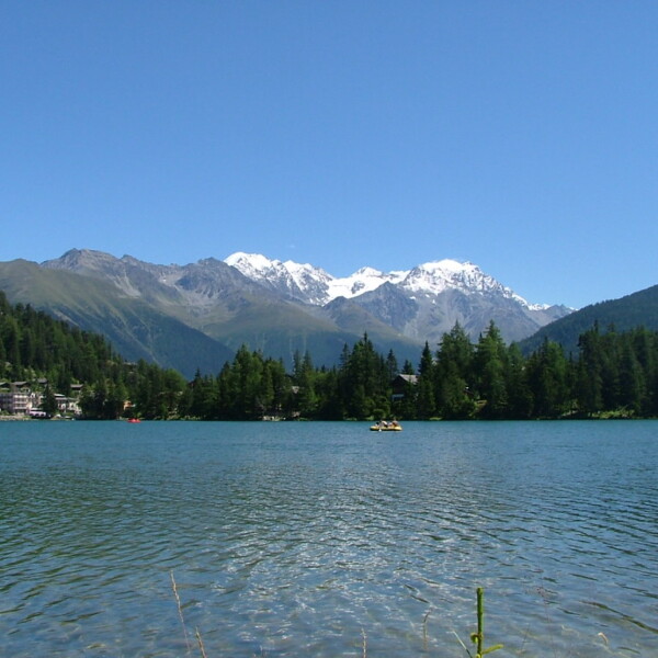 Lac de Champex mit Bergen und Booten an einem sonnigen Tag.