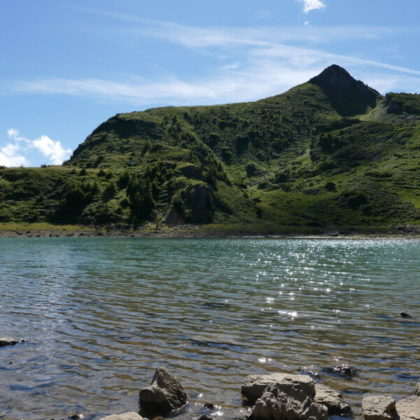 Lac de Chésery mit Berg im Hintergrund, sonniges Wetter.