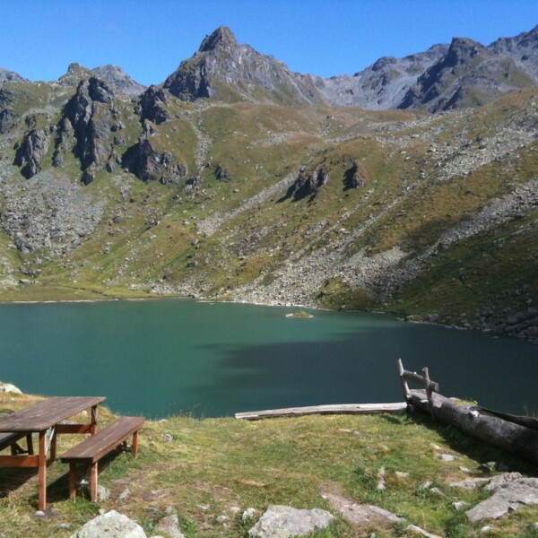 Lac de Louvie: Bergsee mit Picknicktisch und Bergpanorama im Wallis, Schweiz.