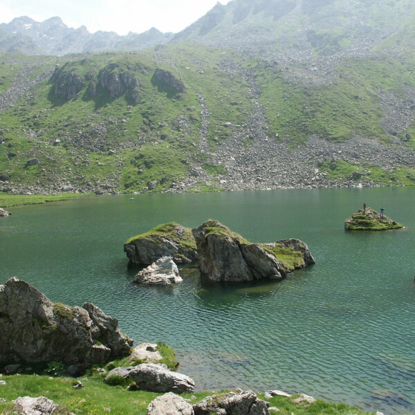 Lac de Louvie: Bergsee mit Felsen und grünen Hängen im Wallis, Schweiz.