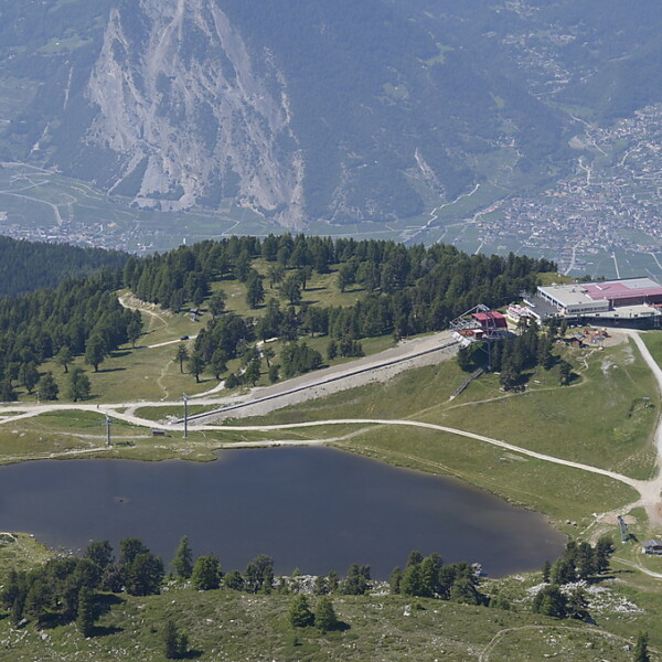 Lac de Tracouet: Bergsee mit Gondelstation und Wanderwegen in den Schweizer Alpen.