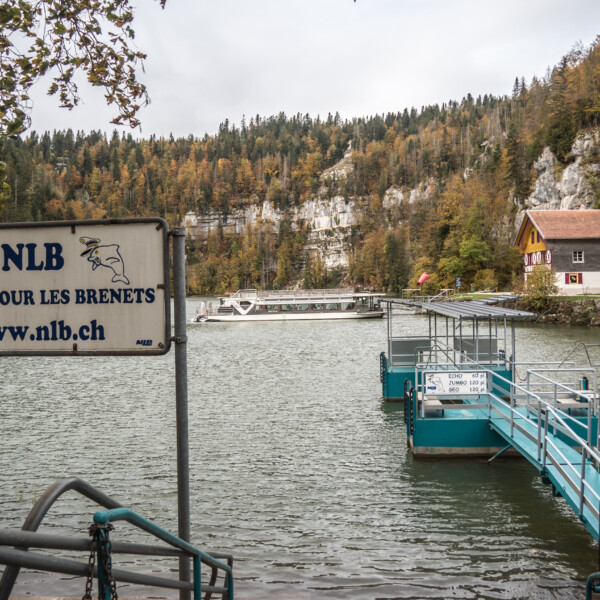 NLB-Boot am Lac des Brenets. Schild: Abfahrt nach Les Brenets, www.nlb.ch