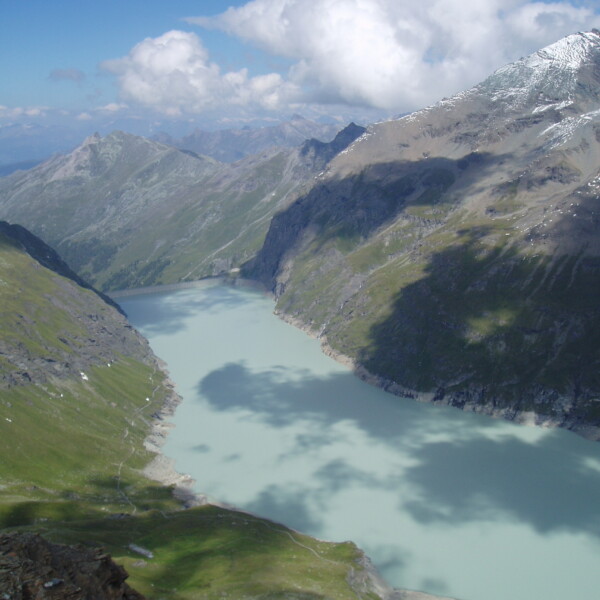 Lac des Dix Stausee in den Schweizer Alpen unter blauem Himmel mit Wolken und Bergen.