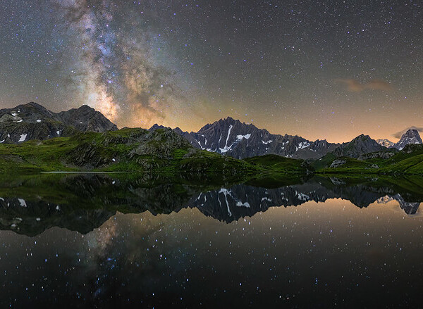 Milchstraße über den Lacs de Fenêtre, reflektiert im ruhigen Wasser. Sternenklarer Himmel über den Bergen.