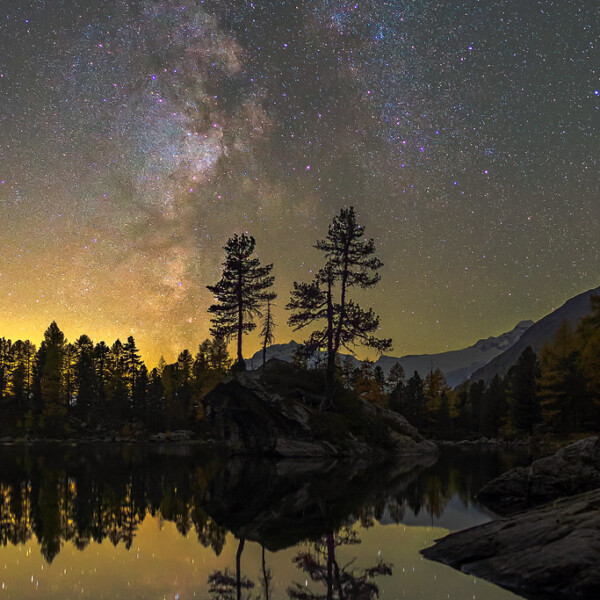 Sternenhimmel über dem Lagh da Saoseo mit Spiegelung im Wasser.