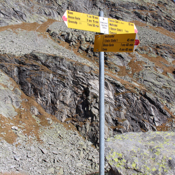 Wegweiser in Bosco Gurin, Tessin. Wanderwege nach Bann, Wolfstaffel und Uessar See.