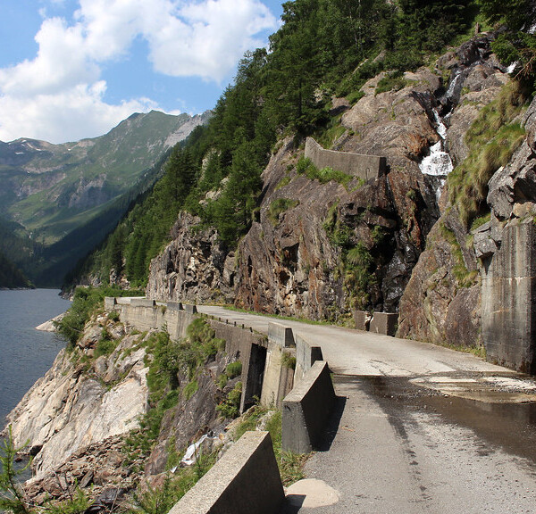 Straße am Lago del Sambuco mit Tunnel und Bergkulisse.