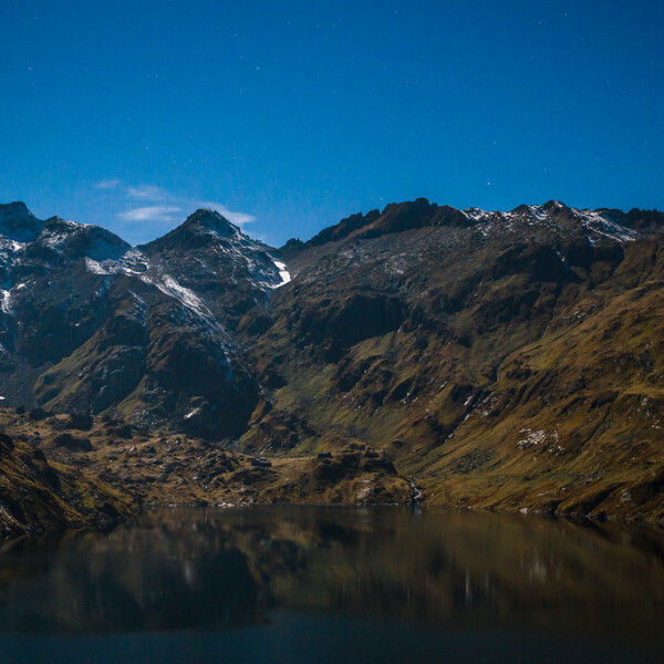 Lago di Lucendro: Bergsee mit Spiegelung der schneebedeckten Gipfel im klaren Wasser.