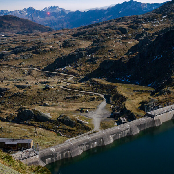 Lago di Lucendro Stausee mit Berglandschaft. Kraftwerk am Seeufer.