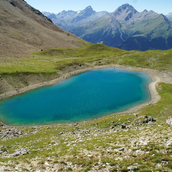 Lai Tigiel: Alpiner Bergsee mit türkisfarbenem Wasser in Graubünden, Schweiz.