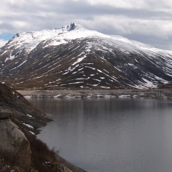 Lai da Sontga Maria See mit schneebedecktem Berg im Hintergrund.