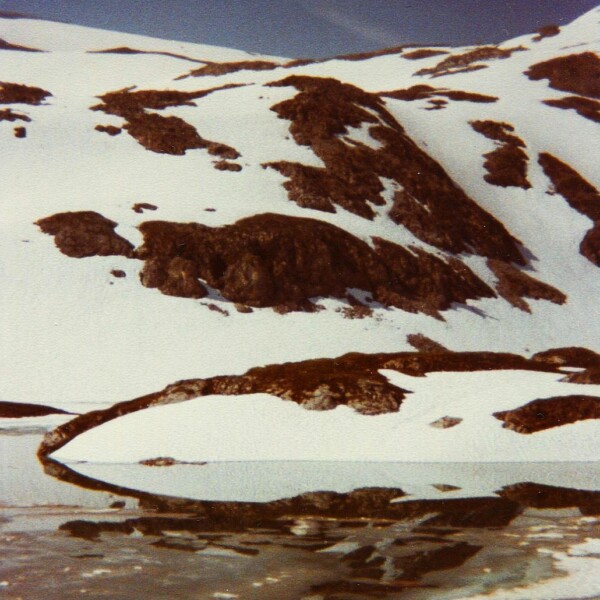 Lais da Rims: Verschneite Berglandschaft mit See und Reflexionen.