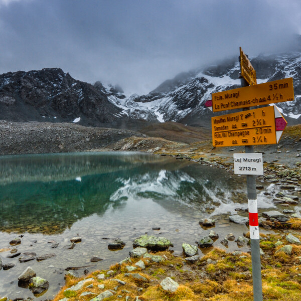 Lej Muragl: Bergsee mit Wegweiser zu Fcia. Muragl, La Punt Chamues-ch und Muottas Muragl.
