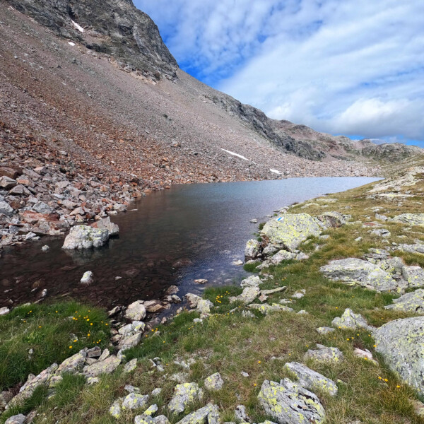 Lej da las Collinas: Bergsee in Graubünden, umgeben von Felsen und alpiner Vegetation.