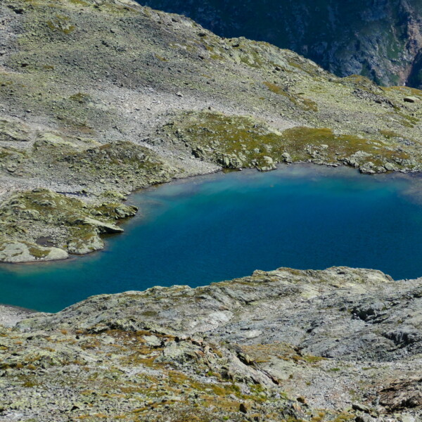 Lej dal Rosatsch: Alpiner Bergsee mit türkisfarbenem Wasser umgeben von Felsen.