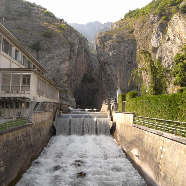 Lizerne: Wasserfall und Schlucht mit Gebäude am Ufer.