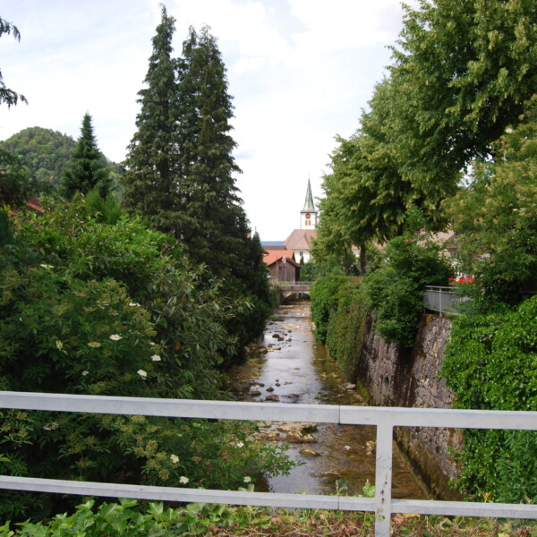 Fluss Lüssel mit Blick auf eine Kirche, umgeben von üppigem Grün.