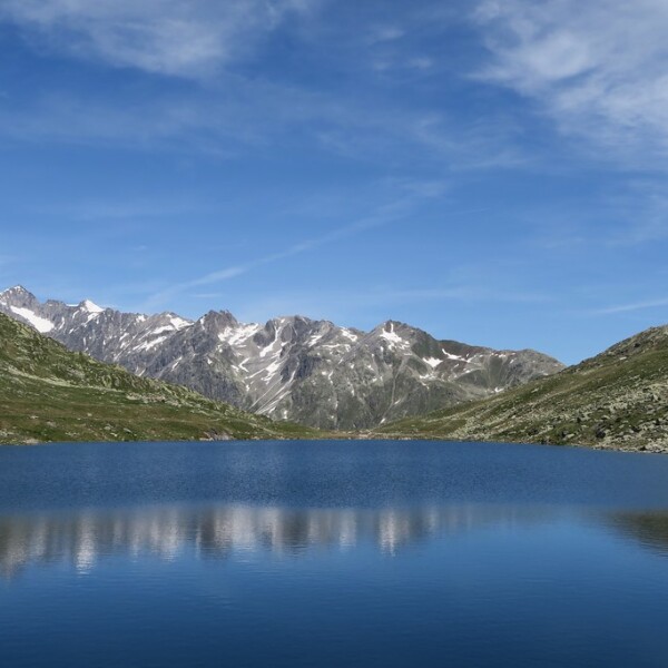 Märjelensee: Blauer Bergsee mit Spiegelung und schneebedeckten Bergen im Hintergrund.