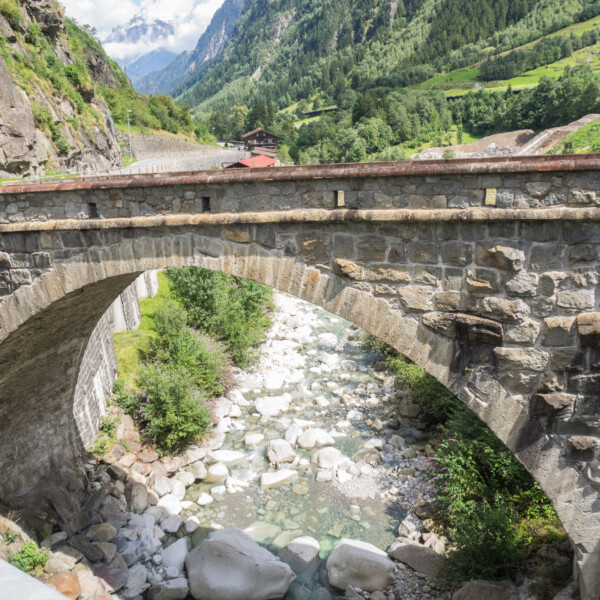 Steinerne Bogenbrücke über den Meienreuss-Bach in einer grünen Landschaft.