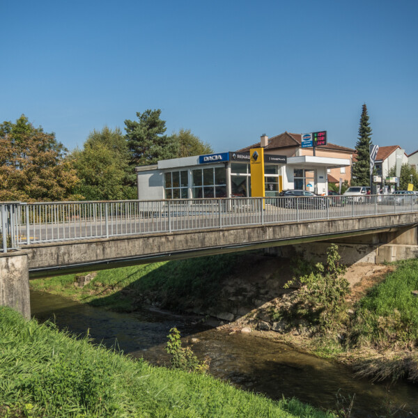 Dacia und Renault Autohaus neben der Mentue, überbrückt von einer Brücke.