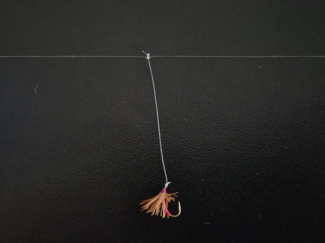 Sbirolino-Fliege am Bergsee-Vorfach. Angelhaken mit Federn.