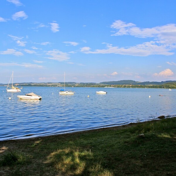 Segelboote auf dem Murtensee (Lac de Morat) unter blauem Himmel mit Wolken