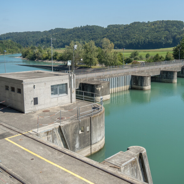 Niederriedsee: Staumauer mit türkisfarbenem Wasser und bewaldeten Hügeln im Hintergrund.