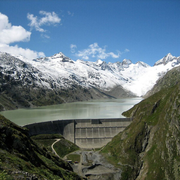 Oberaarsee Stausee mit schneebedeckten Bergen im Hintergrund.