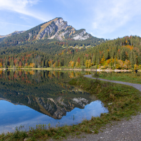 Obersee (Glarus) mit Bergspiegelung im Herbst. Wanderweg am Seeufer.