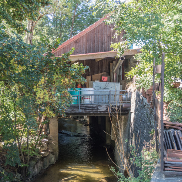 Alte Mühle über Petite Glâne Fluss, umgeben von Bäumen.