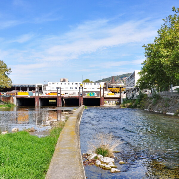 Sihl Fluss mit Wehr und Gebäuden im Hintergrund, Zürich.