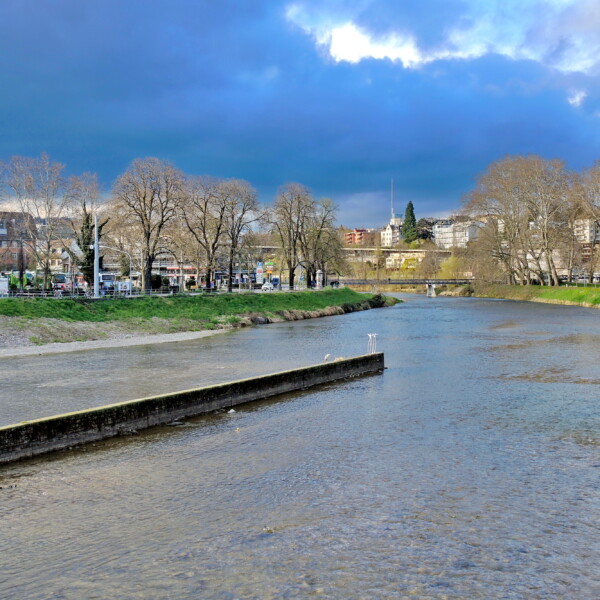 Sihl Fluss in Zürich, Schweiz unter bewölktem Himmel. Stadtansicht im Hintergrund.