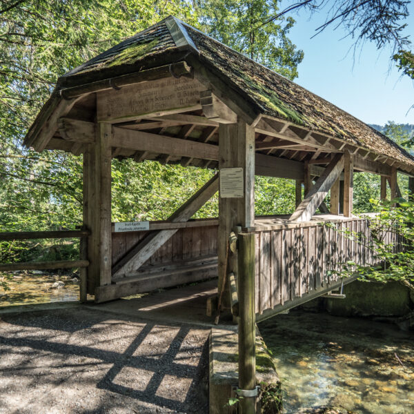 Holzbrücke mit Dach über dem Fluss, Privatbesitz Johanneum. Text: Inseli-Kapelle, Privatbesitz Johanneum.