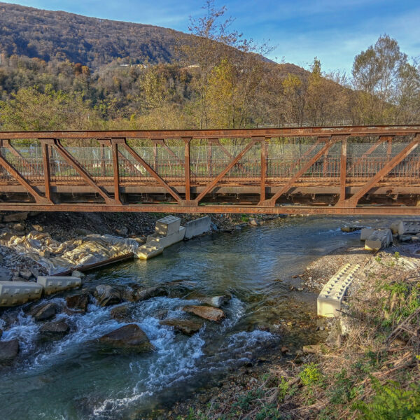Rostige Brücke über den Vedeggio Fluss in einer grünen Landschaft.