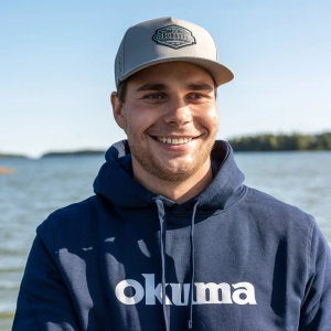 Mann mit Okuma Kapuze und grauem Snapback-Cap mit gesticktem Logo.